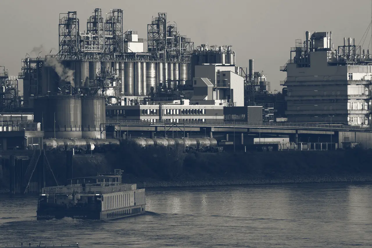 Industrial plant and barge on a river at dawn